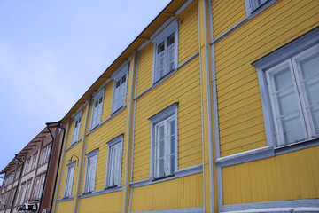 Fototapeta na wymiar A yellow wall of a building with a cloudy blue sky