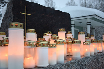 Candles in front of a black Christian gravestone