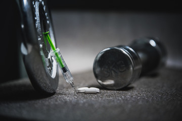 sport stimulants. metal barbells with syringe
