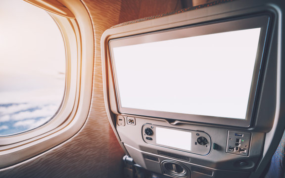 Empty White Mockups Of Aircraft Multimedia Screens With Remote Control, Close-up View Of Blank Template Of Airplane Monitor In Passenger Seat: Multiple Buttons And Sockets, Porthole On The Left