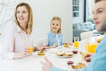 happy family looking away while having breakfast together at home