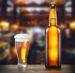 bottle is glass of fresh beer on the table of a brewery