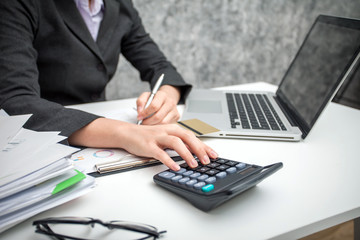 Business women using calculator at working with financial reports