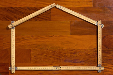 House Shaped Folded Measuring Stick on Wooden Background