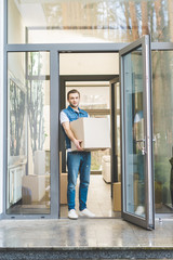 man with cardboard box moving new house