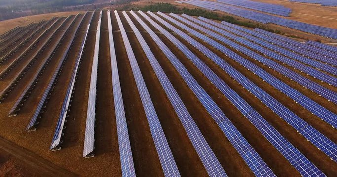 Drone flight over a solar power plant in agricultural landscape. Industrial background on renewable resources theme. Industry of power and fuel generation in European Union. 