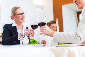 Women on business lunch toasting with wine to celebrate an agreement