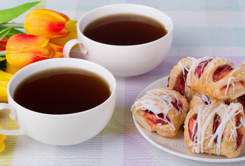 Strawberry pastries on a plate with coffee and flowers