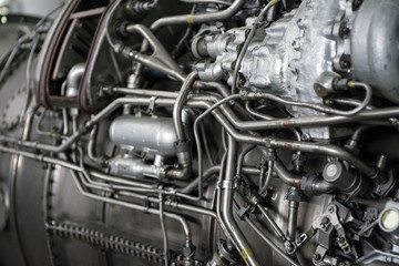 Fragment of a complex mechanical aggregate with various communication and control organs. Engine fragment of a military aircraft. Selective focus.