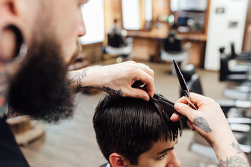 man getting trendy haircut at barber shop.