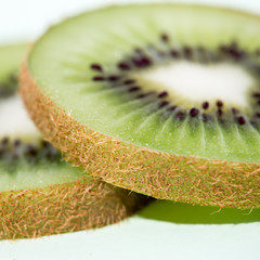 Naklejka na ściany i meble sliced kiwi fruit isolated on green background, pop art color technical