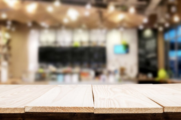Selected focus empty brown wooden table and Coffee shop or restaurant blur background with bokeh image. for your photomontage or product display.