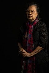 Asian senior woman holding walking stick