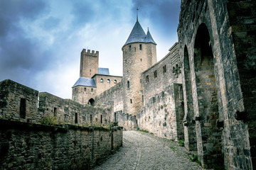 Castle walls of Carcassonne fortress in France with crowd clouds on the background