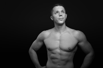 Fototapeta na wymiar Portrait of a shirtless athletic guy, black background