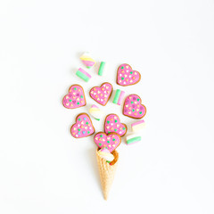 Gingerbread cookies and marshmallow in waffle cone on white background. Flat lay. top view.