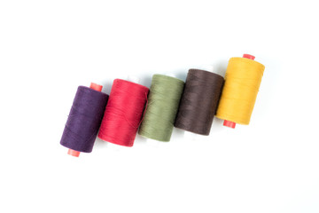 Colored thread coils on white background, sewing