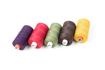 Coloured thread coils on white background, sewing