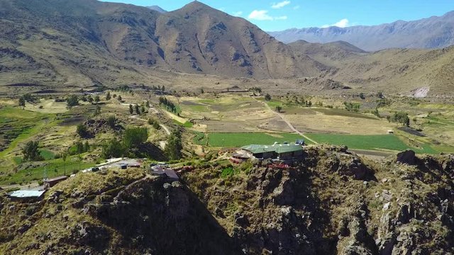 Drone aerial flying backwards away from a beautiful house overlooking the valley of Colca Canyon in Peru