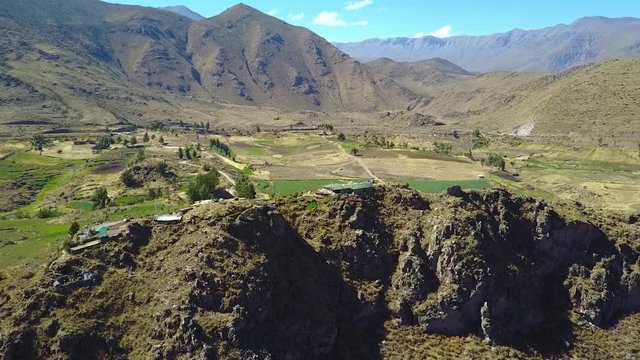 Stunning cinematic aerial flying backwards over the Colca Canyon valley in Peru along the Andes Mountain range