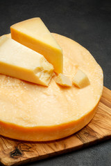 Whole round Head of parmesan or parmigiano hard cheese on concrete background