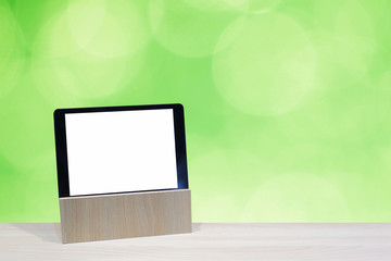 tablet on the table wooden with green background
