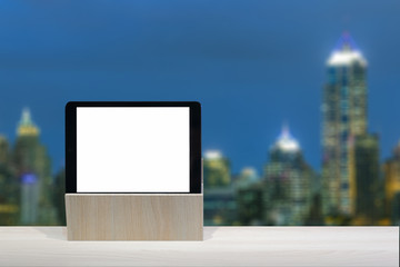 tablet on the table wooden with blurred night city scape background