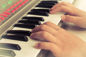 Obraz premium child plays on piano, synthesizer. Concept Training, Education, School