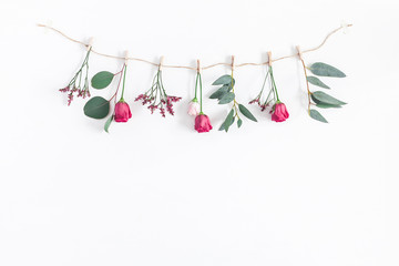 Flowers composition. Garland made of various colorful flowers and eucalyptus branches on white background. Flat lay, top view, copy space