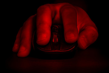 The hand lies on the computer mouse. Gamer