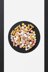 Medication white colorful round tablets arranged abstract in circle on white black background. Aspirin, capsule pills design. Treatment, choice healthy lifestyle concept. Copy space for advertisement.