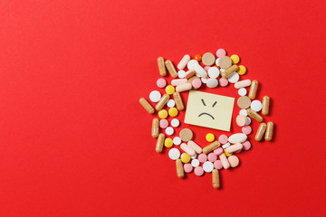 Medication white colorful round tablets arranged abstract on red color background. Aspirin, capsule...