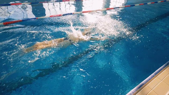 A slow motion of a female swimmer making a butterfly stroke. 