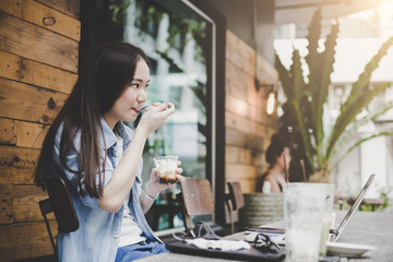 Young asian hipster woman relax and enjoy online social network through laptop computer at home on weekend, lifestyle people