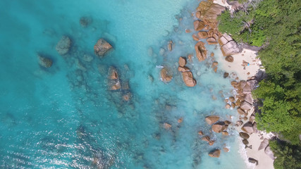 Overhead aerial view of beauiful tropical beach with stones and trees