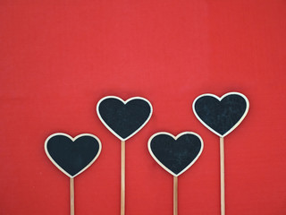 Plakat Black wood hearts on a red background. Copy space.