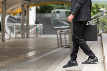 Businessman holding a handbag and walking downstairs