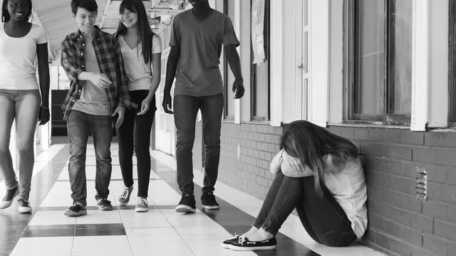 School bullying concept. Asian girl mobbed by multi ethnic teenagers group, black and white view
