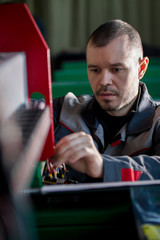 Portrait of electrician on overalls is working with energy panel and machinery equipment on plant