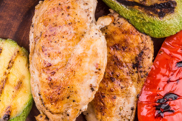 Fried chicken fillet with grilled vegetables close-up, macro