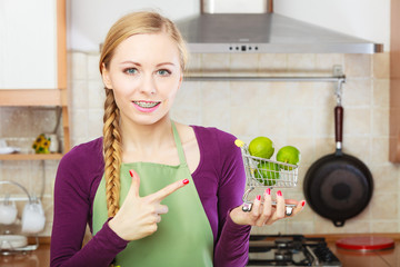 Woman holding shopping cart with limesinside