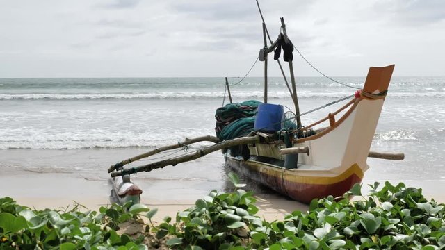Footage of a fishing boat in the Weligama bay with the ocean in the background. Slowmotion shot in 4k.