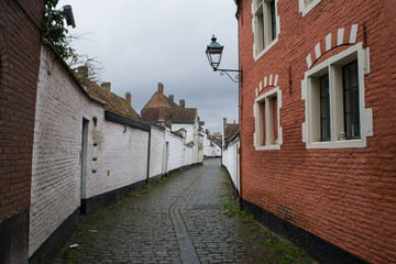 Fototapeta na wymiar Brick houses and cobblestone streets of the Beguinage in Ghent, Flanders, Belgium