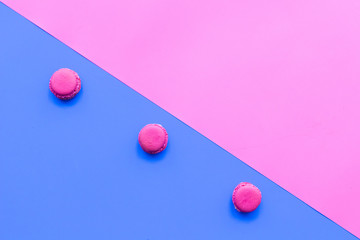 Macarons dessert. Pattern on blue and pink pastel background top view copy space