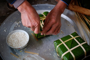 Packing Banh Chung (sticky rice cake), this is a traditional Vietnamese rice cake which is made from glutinous rice, mung beans, pork and other ingredients.