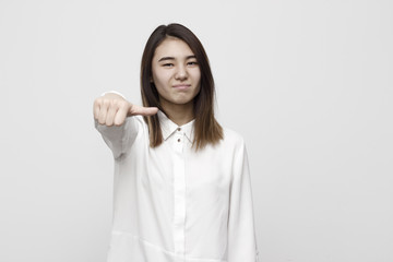 Woman giving an equal thumb gesture with a grimace showing that she is undecided, abstaining,...