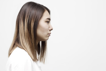 Indoor side view portrait of young pretty woman. Close up profile of businesswoman in white formal shirt