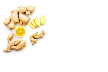 Fresh ginger root near lemon slices on white background top view copy space