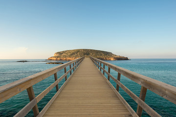 Fototapeta na wymiar Wooden footbridge by the water to an island