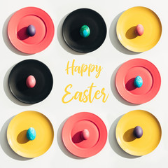 top view of easter eggs on colorful plates with Happy Easter lettering